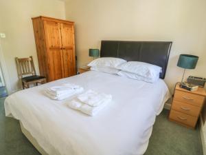 a bedroom with a bed with towels on it at Bramble Cottage in Sedbergh