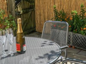 a bottle of champagne sitting on a table with glasses at Bramble Cottage in Sedbergh