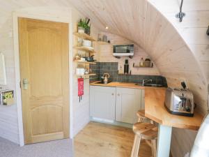a kitchen with an archway in a tiny house at Idris Pod in Tremeirchion +10 photos