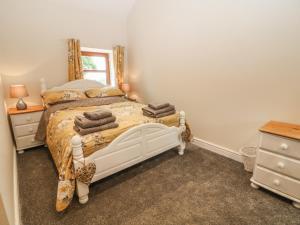 a bedroom with a white bed and a mirror at Y Deri Cottage in Llandwrog