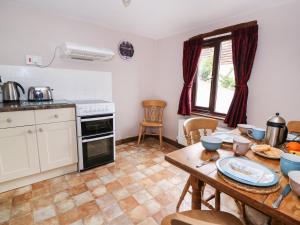 a kitchen with a wooden table and a kitchen with a dining room at Beech Cottage in Llanidloes