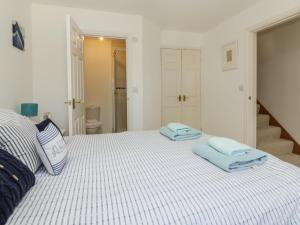 a bedroom with a bed with two towels on it at Strawberry Cottage in Penryn
