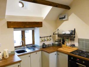a kitchen with a sink and a stove at The Old Cottage in Weston-super-Mare