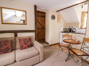 a living room with a couch and a table at Oak Cottage in Llanidloes