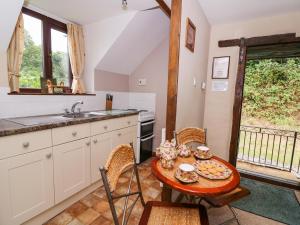 拉尼德洛伊斯的住宿－Oak Cottage，厨房配有桌椅和水槽。