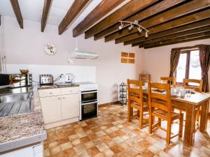 a kitchen with a table and chairs in a room at Cedar Cottage in Llanidloes