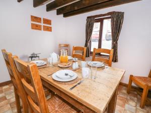 a dining room with a wooden table and chairs at Cedar Cottage in Llanidloes