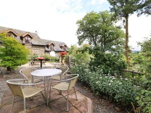 a patio with a table and chairs in front of a house at Cedar Cottage in Llanidloes +12 photos