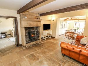 a living room with a fireplace and a couch at The Long View in Hebden Bridge