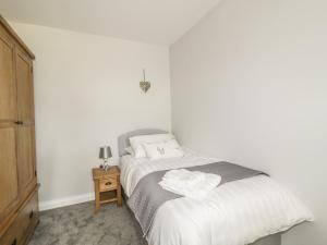 a bedroom with a bed with two towels on it at 1 Leesrigg Cottages in Wigton