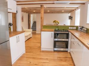 a kitchen with white cabinets and a stove top oven at The Cow Byre, Heath Farm in Clee Saint Margaret