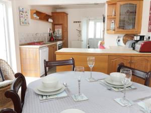 una cocina con una mesa con platos y vasos. en Salty Puffin, en Benllech