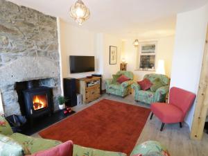 a living room with a fireplace and a tv at Old Post Office in Blaenau-Ffestiniog