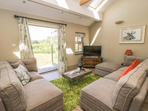 a living room with two couches and a tv at Providence Cottage in Easingwold