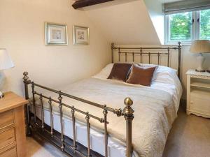een slaapkamer met een bed, een bureau en een raam bij Honeypot Cottage in Kendal