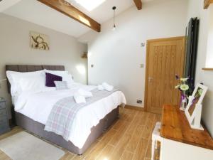 een slaapkamer met een bed en een houten vloer bij Sunnybrook Cottage in Clitheroe