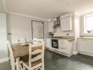 a kitchen with a wooden table and a kitchen with white cabinets at Ivy Bank in Windermere +7 photos