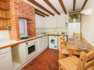 a kitchen with a wooden table and a kitchen with a stove at Blenheim Edge, The Causeway in Woodstock