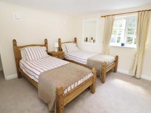 two twin beds in a room with a window at Blenheim Edge, The Causeway in Woodstock