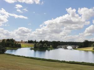 a river with a bridge and clouds in the sky at Blenheim Edge, The Causeway in Woodstock +11 photos