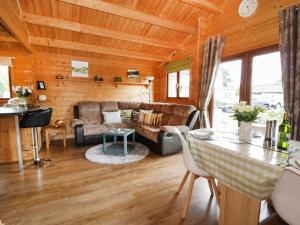 a living room with a couch and a table at Mayfields Lodge in Aston