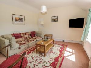 a living room with a couch and a tv at The Cottage in Llangollen