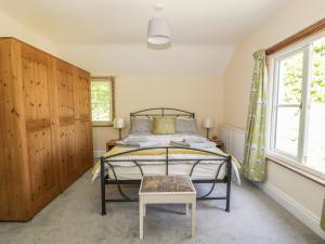 a bedroom with a bed and a chair in it at The Cottage in Llangollen +11 photos