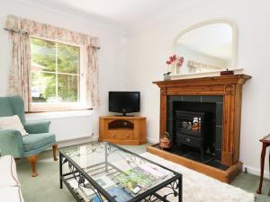 a living room with a fireplace and a tv at Westgate Cottage in Sittingbourne