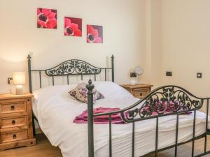 a bedroom with a black bed with white sheets and pink flowers at Orchard Cottage in Kerry