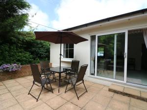 einen Tisch und Stühle mit Sonnenschirm auf einer Terrasse in der Unterkunft Westgate Cottage in Sittingbourne