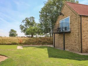 a brick house with a balcony and a yard at Abbey Cottage in Newball