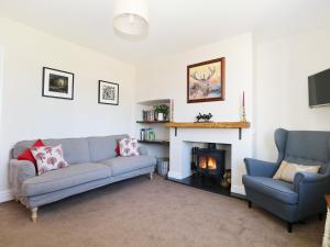 sala de estar con 2 sofás y chimenea en New Park Farm Cottage, en Brockenhurst