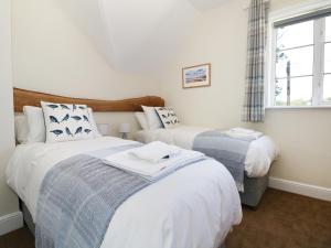 1 dormitorio con 2 camas y ventana en New Park Farm Cottage, en Brockenhurst