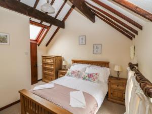 1 dormitorio con 1 cama grande y muebles de madera en The Cottage, en Calton