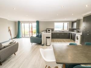 een keuken en een woonkamer met een tafel en stoelen bij 3 Trem Afon in Colwyn Bay