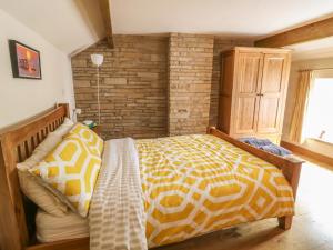 a bedroom with a bed and a brick wall at High Head in Richmond