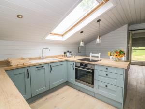 een keuken met blauwe kasten en een dakraam bij Deer Lodge in Blackburn