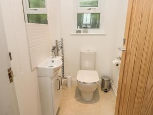 a white bathroom with a toilet and a sink at Sunrise in Filey +14 photos