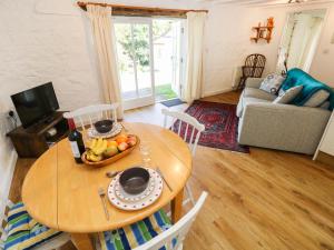 a table with a bowl of fruit on it in a living room at The Granary Cottage in Llangranog