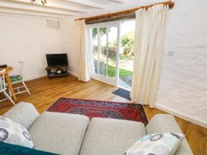 a living room with a couch and a large window at The Granary Cottage in Llangranog