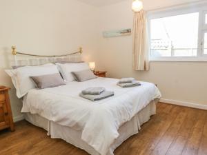 a bedroom with a large white bed with a window at Trem Y Garn in Pwllheli
