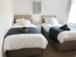 een slaapkamer met 2 bedden en handdoeken bij Evergreen in Ilkley
