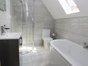 a bathroom with a shower and a toilet and a sink at Corner View in Great Driffield