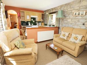 a living room with two couches and a kitchen at Rose Cottage in Great Edston