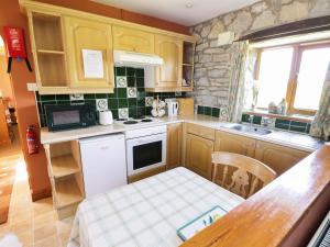 a small kitchen with wooden cabinets and a table at Rose Cottage in Great Edston +10 photos