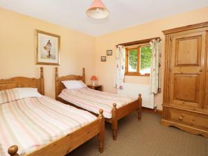 a bedroom with two beds and a window at Rose Cottage in Great Edston