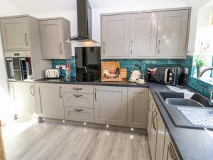 a kitchen with white cabinets and a sink at The Old Mill Hideaway in Ellerton