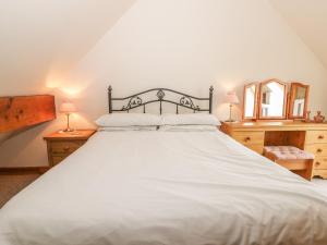 ウィットビーにあるMilton Cottageのベッドルーム(白い大型ベッド、ランプ2つ付)