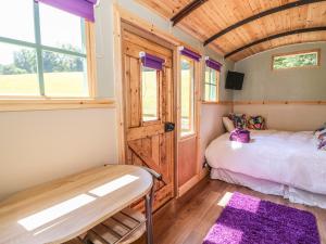 a small bedroom with a bed and a window at Railway Carriage in Abergavenny
