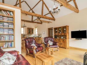 a living room with leather chairs and a flat screen tv at The Cottage in Watchet